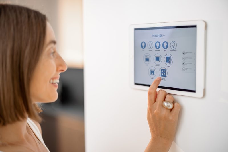 Woman using smart home wall panel to control Tucson home automation system